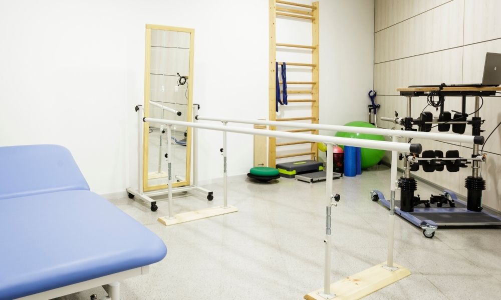 Rehabilitation clinic with parallel bars and mirror for CRPS physiotherapy treatment